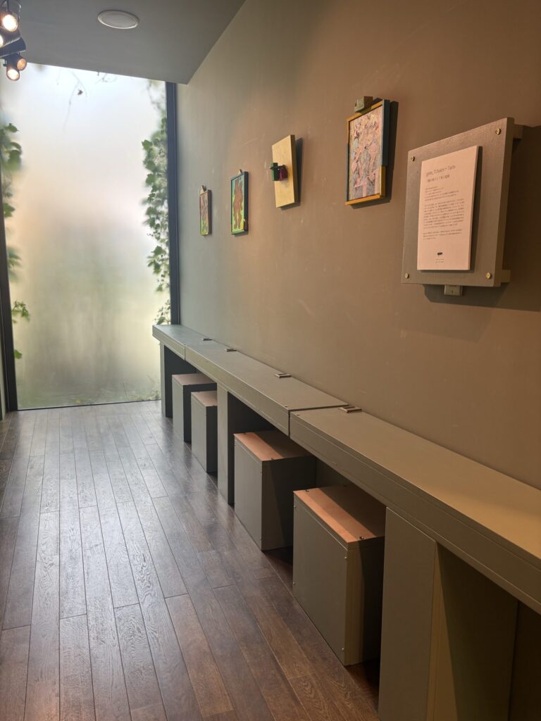 coffee stand gallery göm の展示風景。壁に掛けられた絵画と、その前に並ぶ椅子